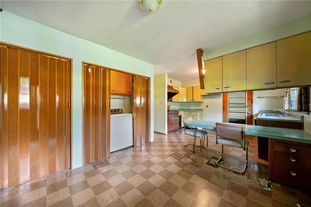 Kitchen featuring light floors, washer / clothes dryer, and white range