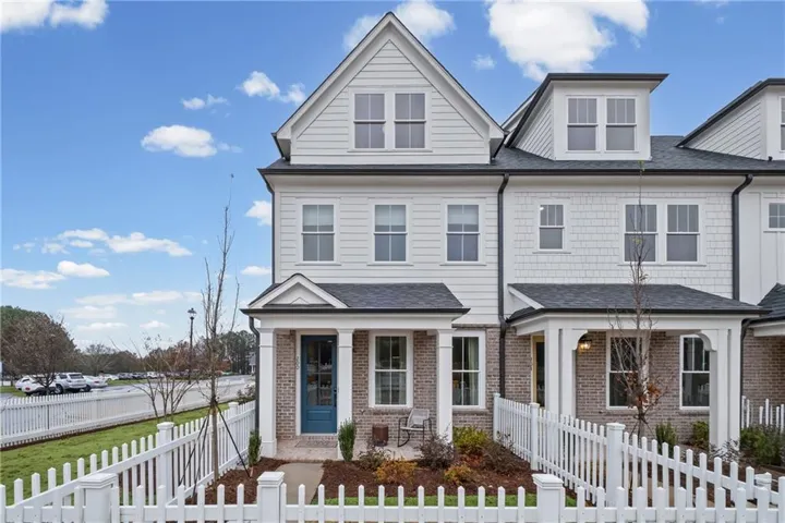 White picket fence enclosing a landscaped front yard