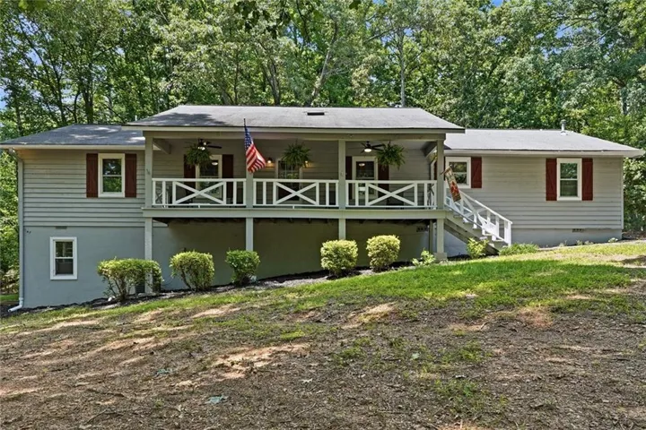 Ranch-style exterior featuring light gray siding and a covered front porch with white railing