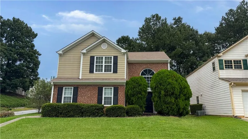 Brick and siding exterior with a peaked roofline