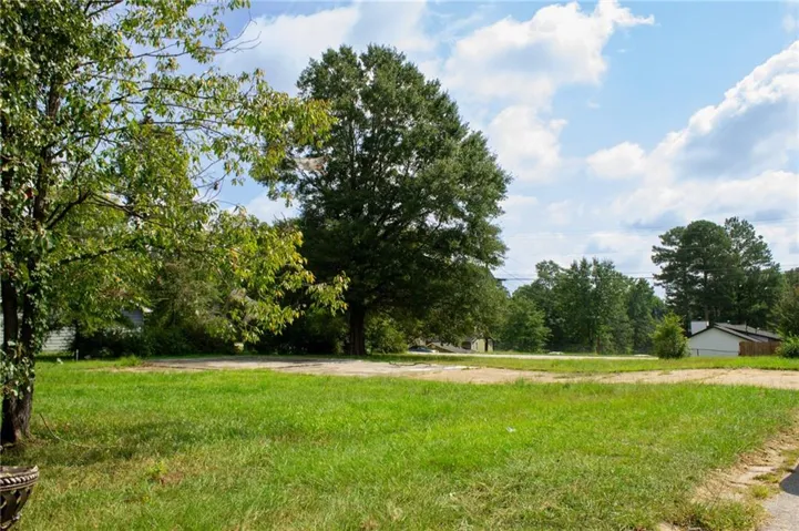 Expansive grassy lot with mature trees