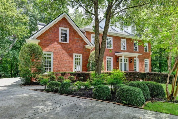 Traditional brick exterior with white trim windows and gabled roofline