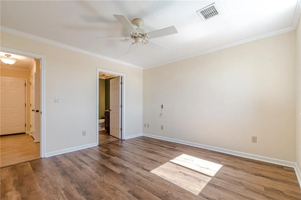 Empty room with crown molding, hardwood / wood-style flooring, a textured ceiling, and ceiling fan