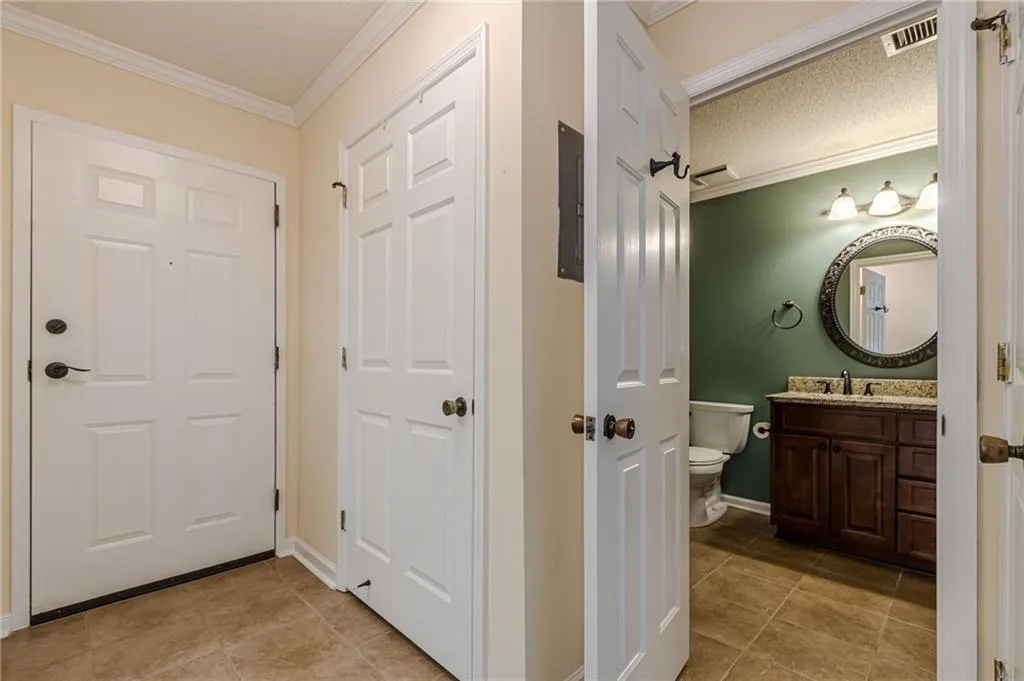 Bathroom with vanity, ornamental molding, toilet, and tile patterned floors