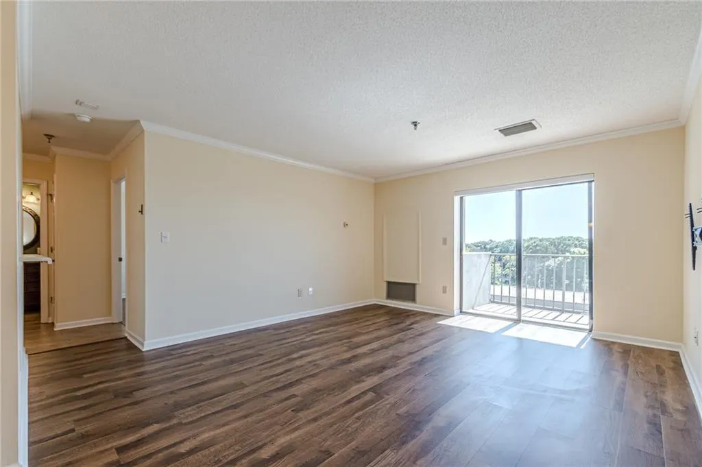 Empty room featuring crown molding, a textured ceiling, and dark hardwood / wood-style flooring