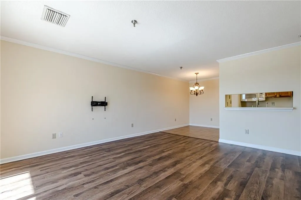 Empty room with crown molding and dark hardwood / wood-style floors