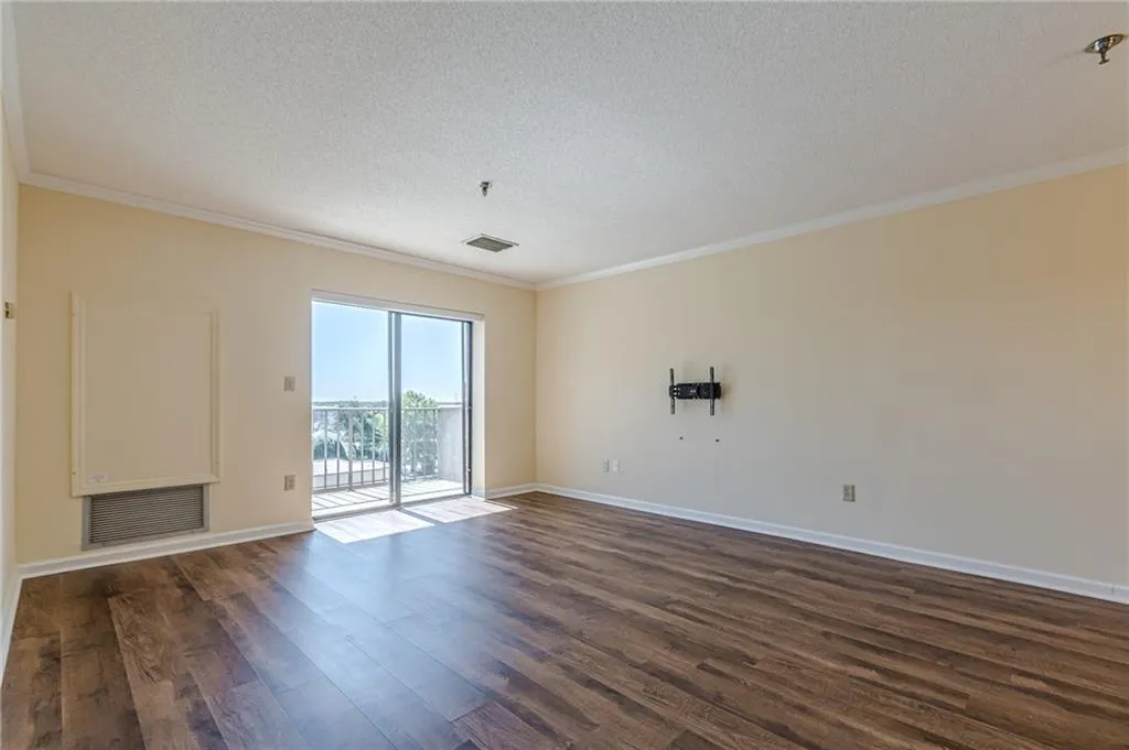 Empty room with ornamental molding, a textured ceiling, and dark hardwood / wood-style flooring
