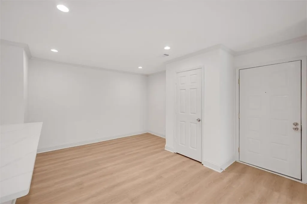 Empty room with crown molding and light hardwood / wood-style floors