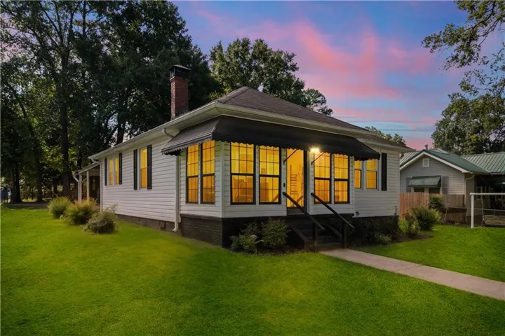 White siding exterior with a dark roof and black window shutters