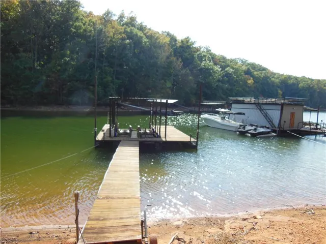 Private dock with wood-finish decking, boat lift, and covered boat slip