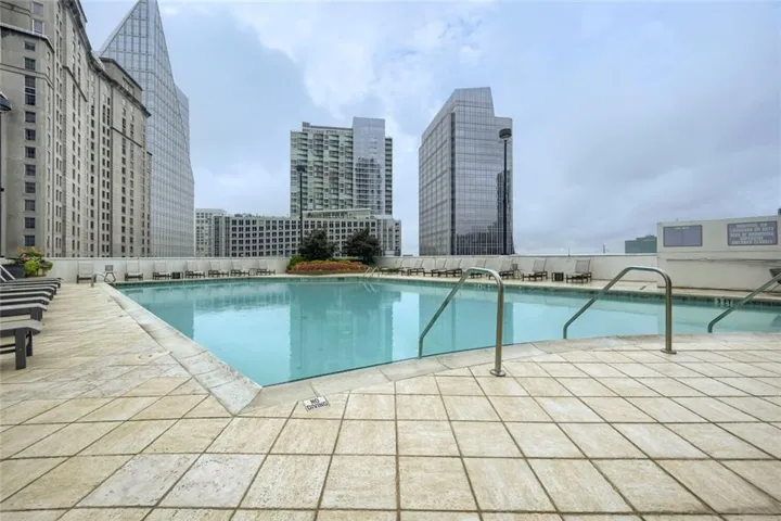 Rooftop swimming pool with integrated entry steps and stainless steel handrails and city view