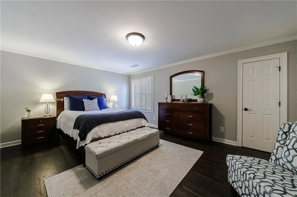 Upstairs bedroom with crown molding and dark hardwood / wood-style flooring