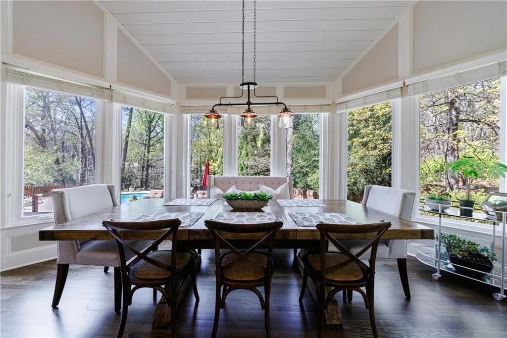 Large eat-in kitchen featuring lofted ceiling, a notable chandelier, and a wealth of natural light