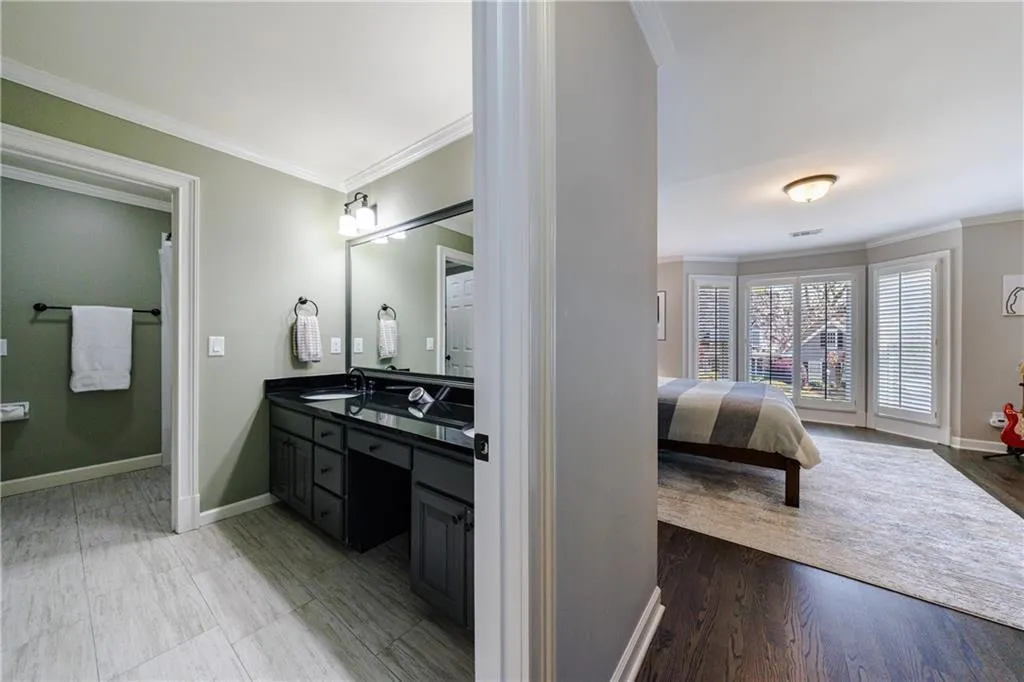 Bathroom featuring separate shower room, double sink, vanity with extensive cabinet space, and tiile flooring, walk-in closet