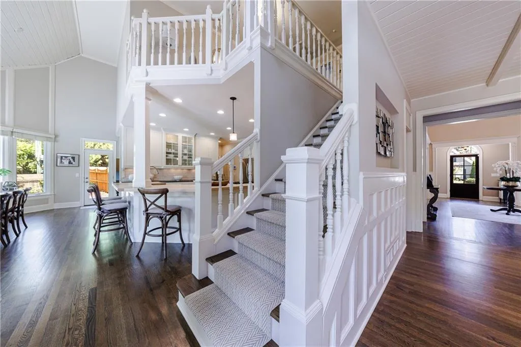 Stairs with high vaulted ceiling and dark hardwood floors