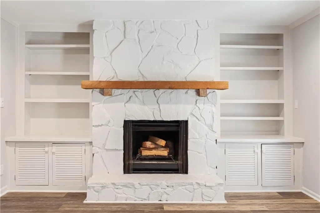 Beautiful fireplace flanked by bookcases and cabinetry.