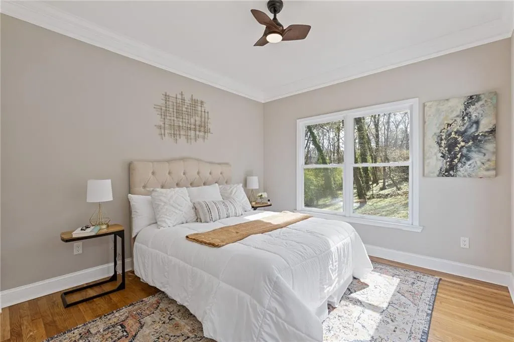 Bedroom featuring crown molding, wood finished floors, and a ceiling fan