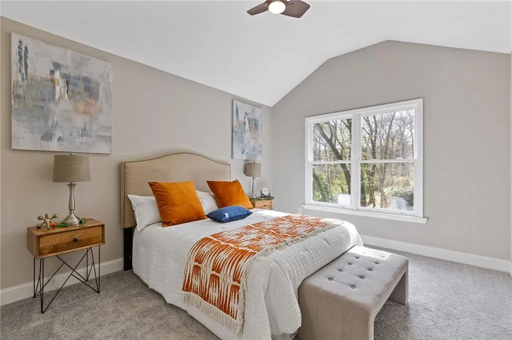 Bedroom featuring carpet floors, vaulted ceiling, and a ceiling fan