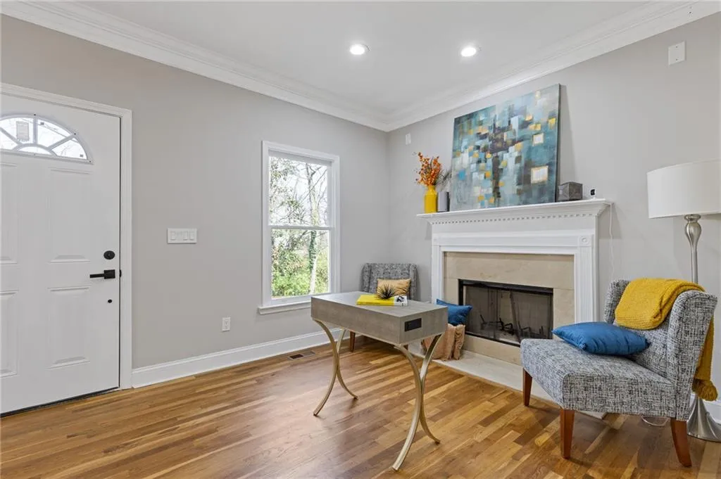 Entrance foyer featuring a fireplace with flush hearth, crown molding, wood finished floors, and recessed lighting