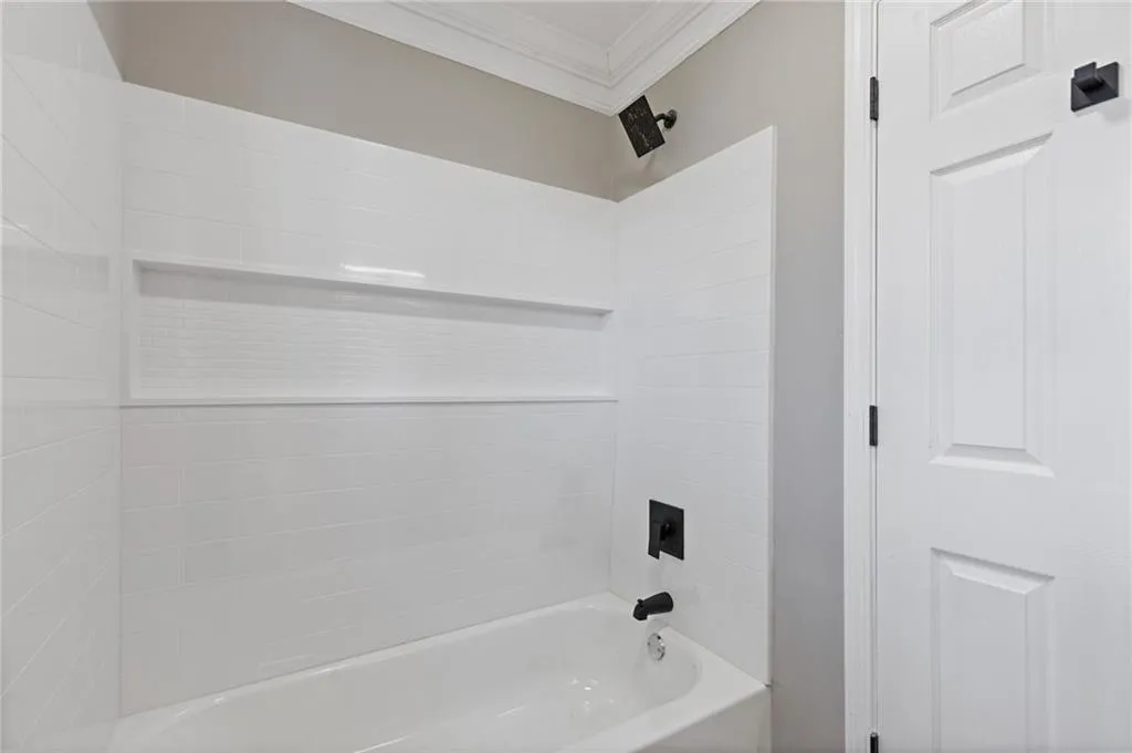 Full bathroom featuring shower / washtub combination and ornamental molding