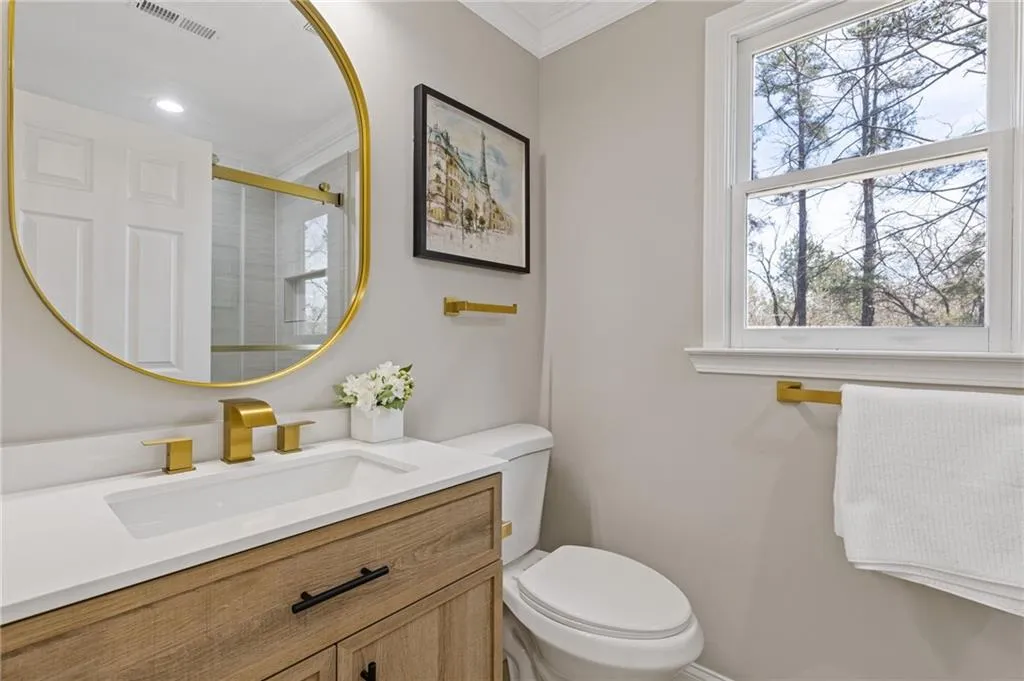Full bath featuring ornamental molding, a stall shower, and vanity