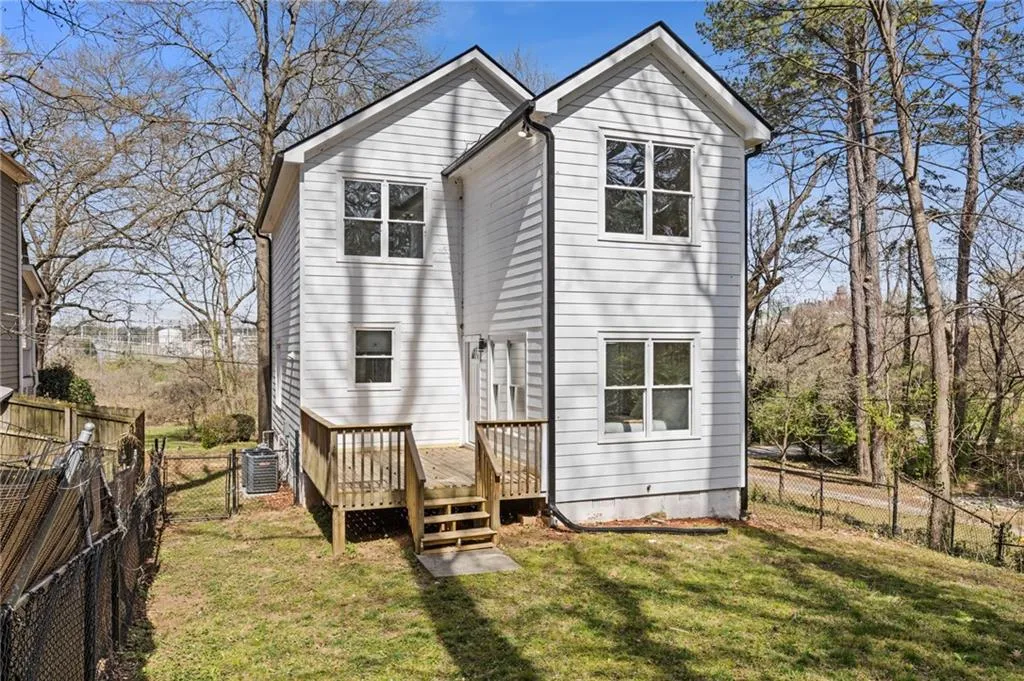 Back of property featuring a fenced backyard and a wooden deck