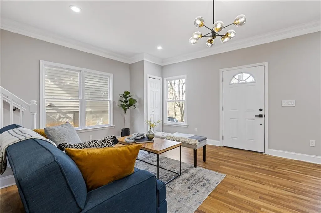 Living area with crown molding, wood finished floors, a chandelier, and recessed lighting
