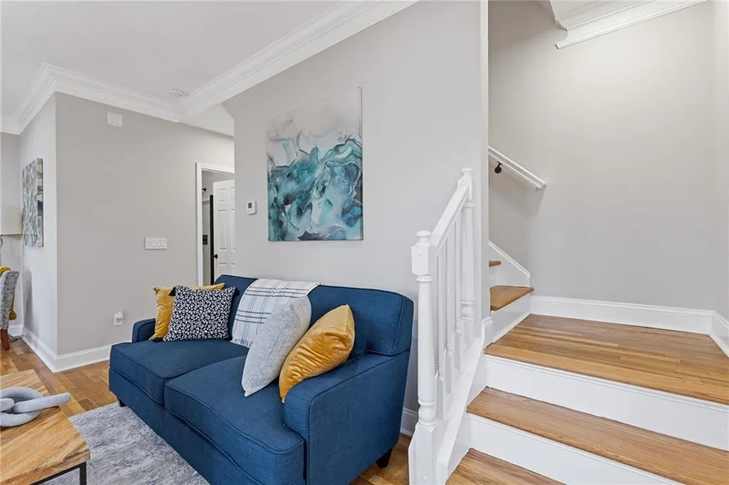 Living area featuring crown molding, stairway, and light wood-type flooring