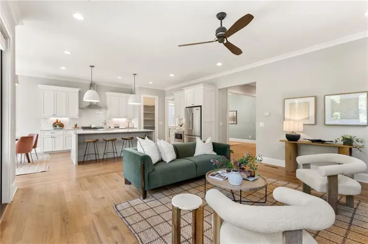 Open-concept living space featuring wood-finish flooring, recessed lighting, and a ceiling fan