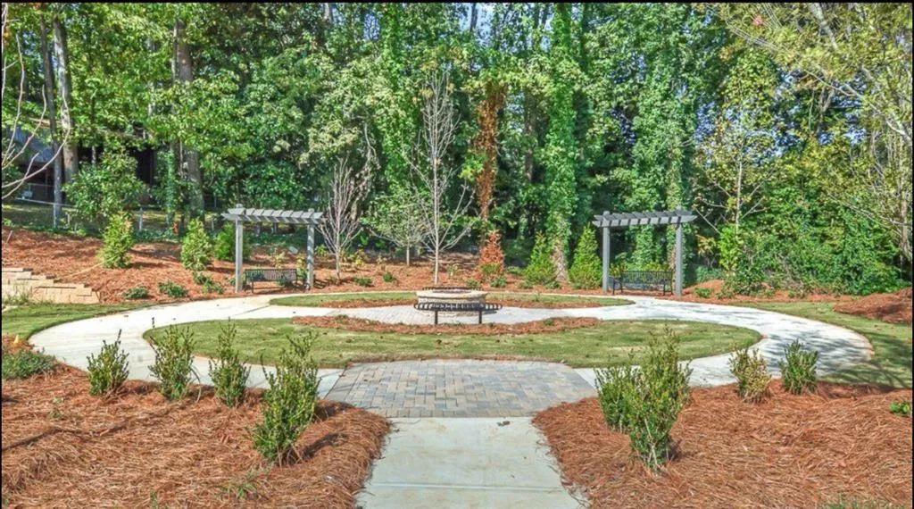 View of community featuring a pergola and an outdoor fire pit