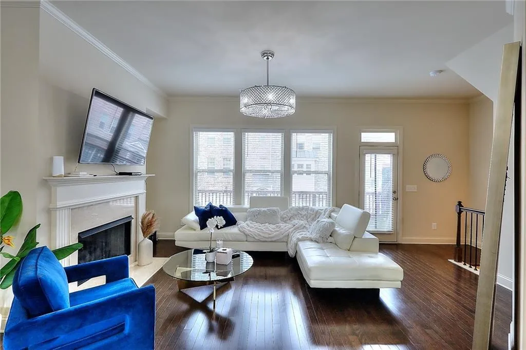 Living room featuring hardwood / wood-style floors, a high end fireplace, and crown molding