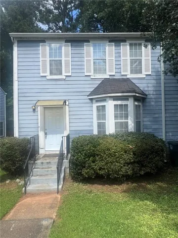 Two-story exterior with siding, a bay window, and a front entry with handrails
