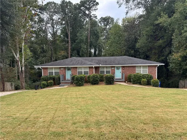 Single story home with a front lawn and brick siding
