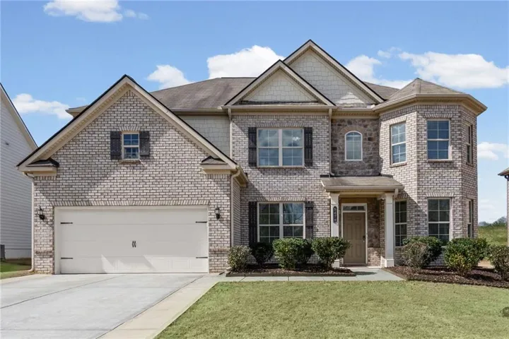 Elegant two-story brick colonial featuring a welcoming front facade with multiple gabled rooflines and architectural detail