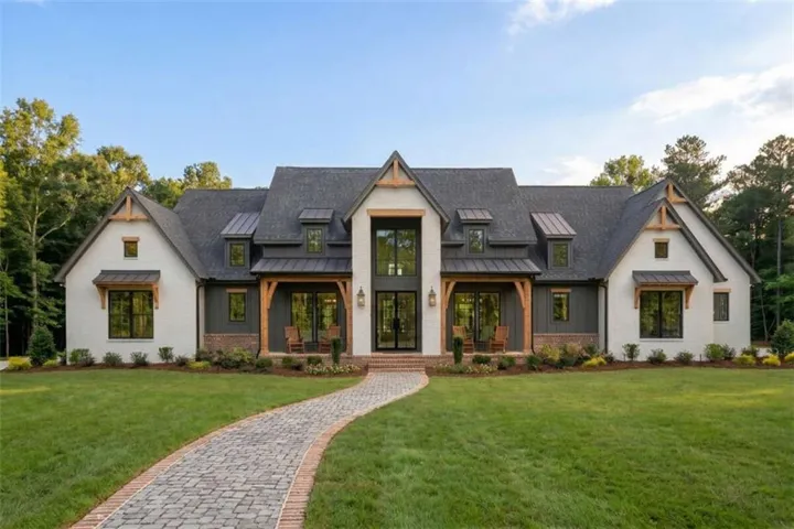 White brick and dark siding exterior with prominent gables
