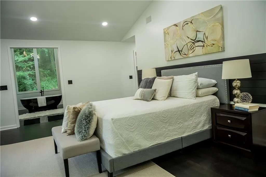 Bedroom with dark wood-type flooring, recessed lighting, and vaulted ceiling