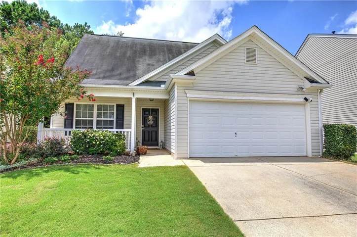 Siding exterior with a covered porch, an attached garage, and a concrete driveway