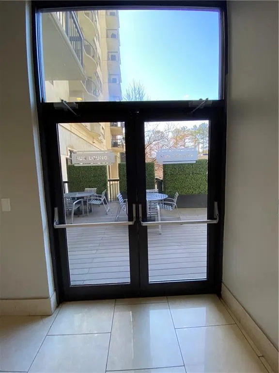 Doorway with tile patterned flooring, baseboards, and french doors