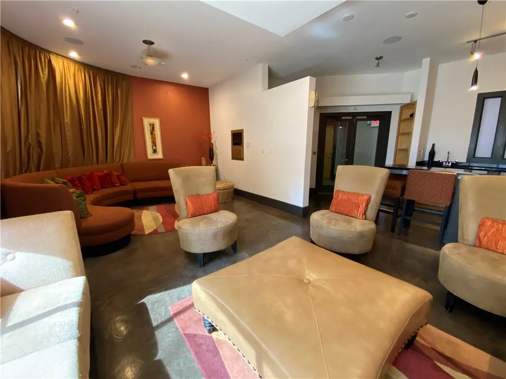 Living room with finished concrete floors, baseboards, and recessed lighting