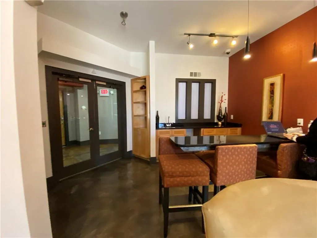 Dining space featuring concrete flooring, french doors, visible vents, and track lighting