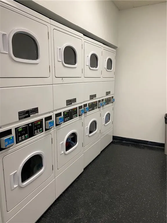 Common laundry area with baseboards, washer and clothes dryer, and stacked washer / dryer