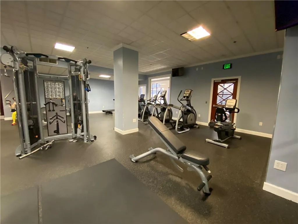 Workout area with a drop ceiling and baseboards