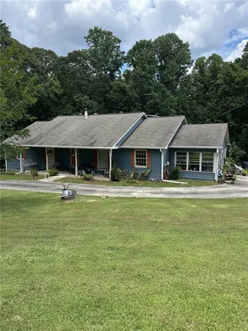 Ranch-style home with a front yard and a shingled roof