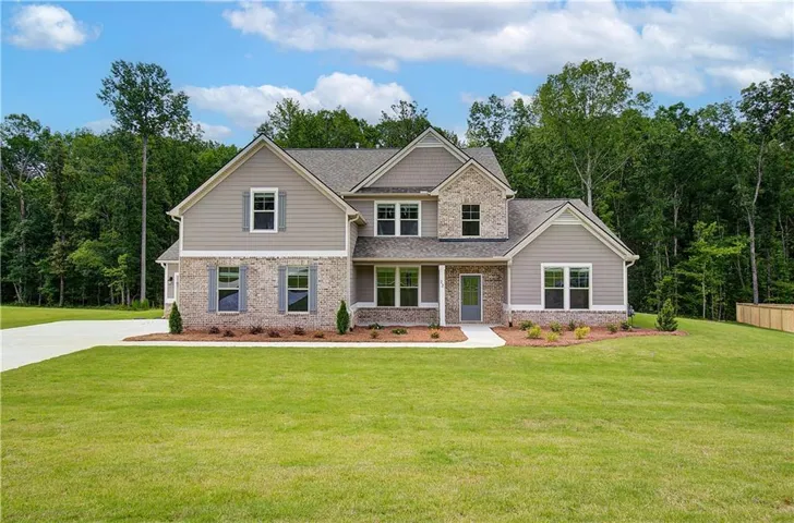 Two-story residence featuring a combination of brick and siding facade, multiple gables, a covered entry, and a concrete driveway