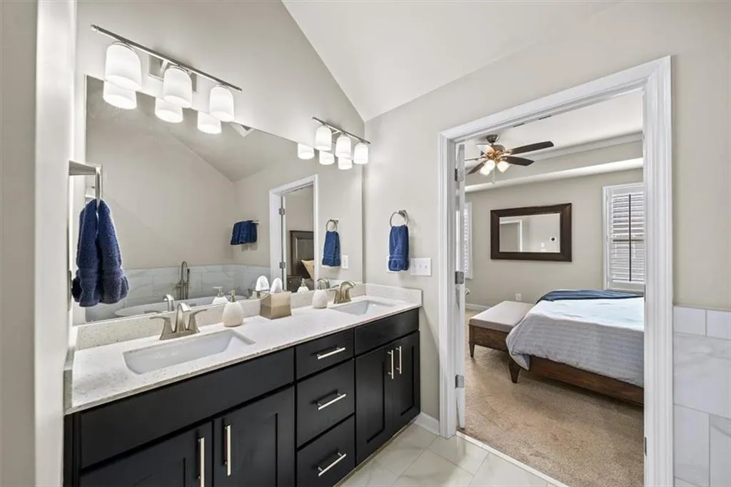 Bathroom featuring vanity, vaulted ceiling, and ceiling fan