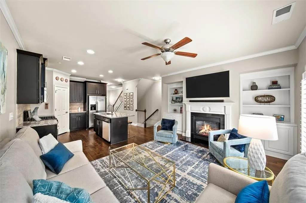 Living room with ornamental molding, sink, dark wood-type flooring, and ceiling fan