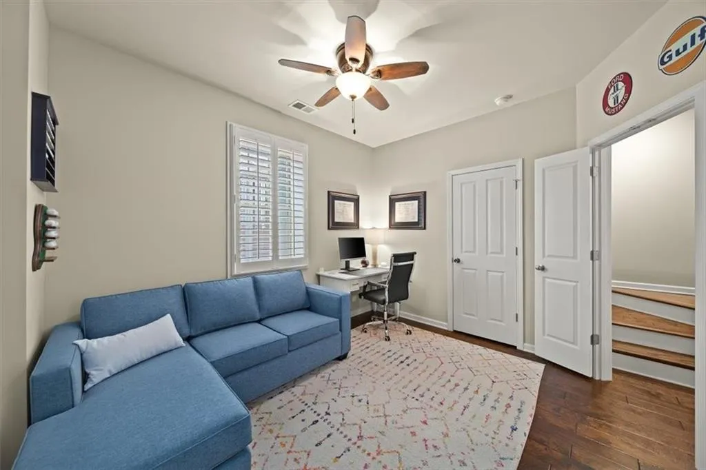 Office area with dark hardwood / wood-style floors and ceiling fan