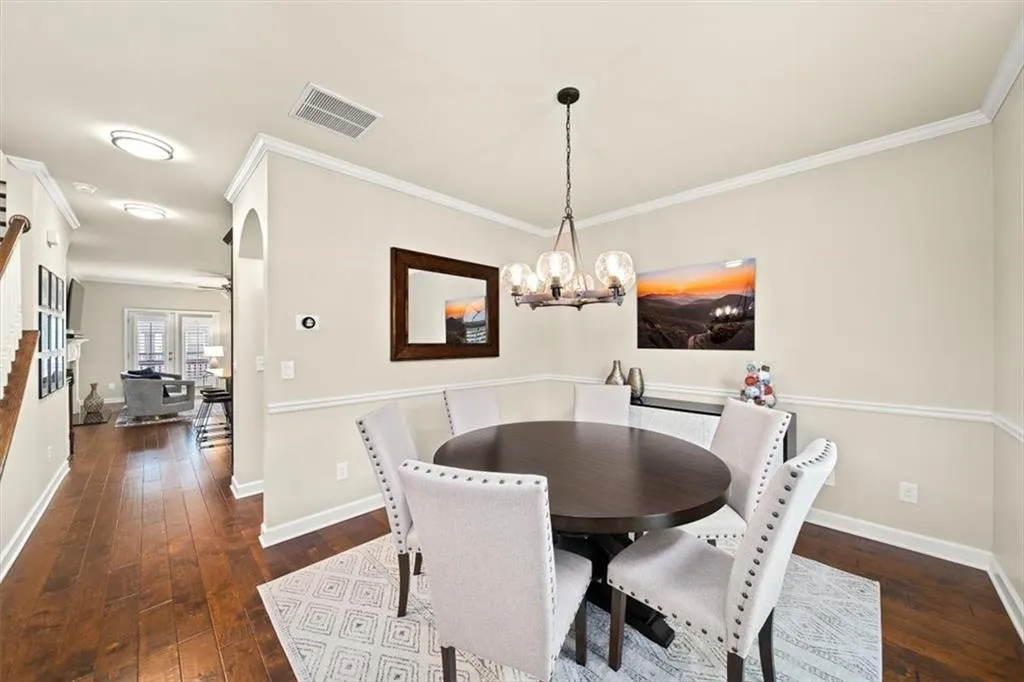 Dining area featuring an inviting chandelier, crown molding, and dark hardwood / wood-style floors