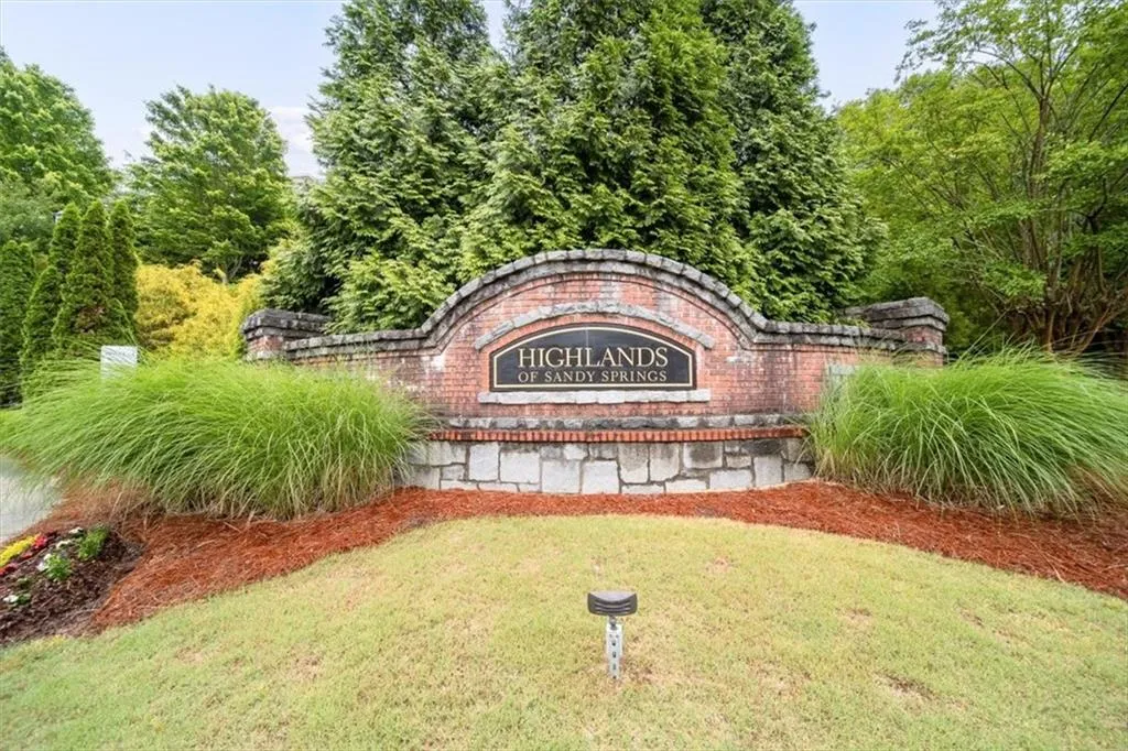 Community / neighborhood sign featuring a yard