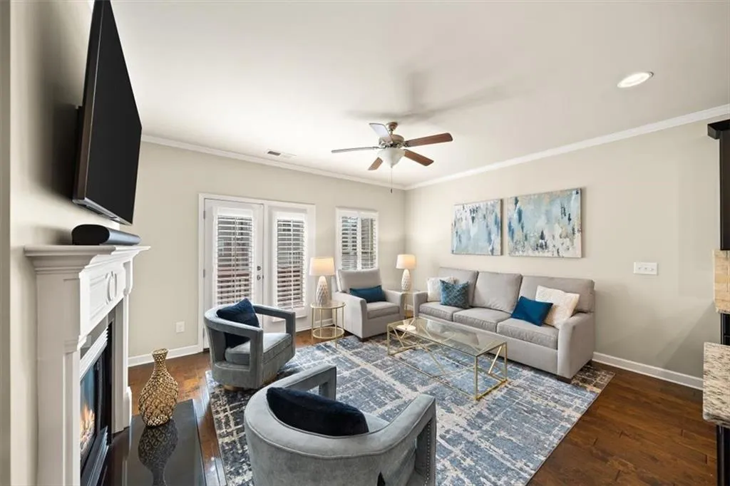 Living room featuring crown molding, ceiling fan, dark wood-type flooring, and french doors